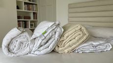 Four of the best duvets - the scooms down duvet, Silentnight half and half, Woolroom washable duvet, and IKEAs on a bed
