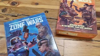 Mutant Year Zero: Zone Wars core box and expansion on a wooden surface