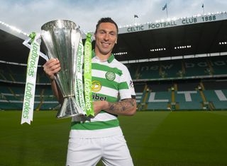 Celtic captain Scott Brown poses with the Scottish Premiership trophy after the Glasgow side are announced as champions in May 2020, with the season incomplete due to the Covid-19 pandemic.