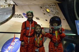 Sofia and Matthew Bogle, ages 9 and 6, and John John Humphries, 5, dressed up for the opening of the Space Shuttle Atlantis exhibition at Kennedy Space Center in Florida on June 29, 2013.