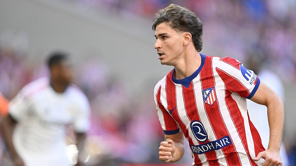 Julian Alvarez, wearing red and white of Atletico Madrid, runs during a game.