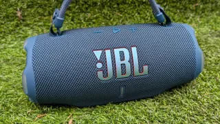 The JBL Charge 6 in blue on a green background. 