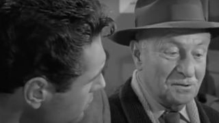 A close up of two men talking to each other in The Twilight Zone episode What You Need