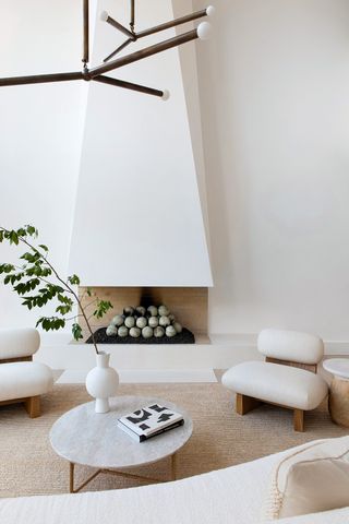 tall white fireplace in a white living room