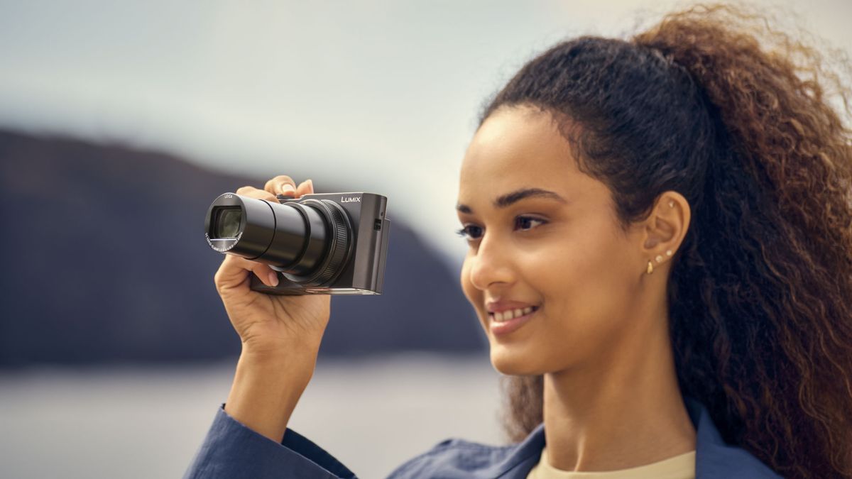 Panasonic Lumix TZ300 travel compact camera in woman's hand, lens extended