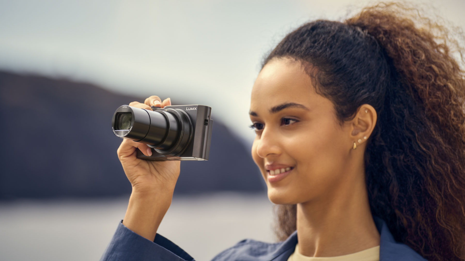 Panasonic Lumix TZ300 travel compact camera in woman's hand, lens extended