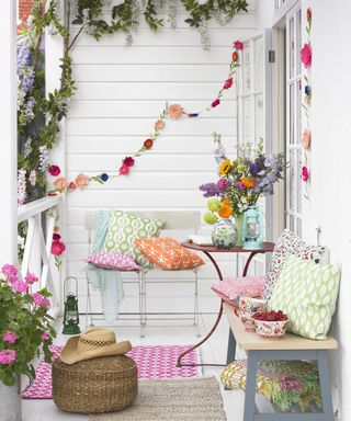 Colourful floral bunting on a plain white wall with pops of colourful accessories