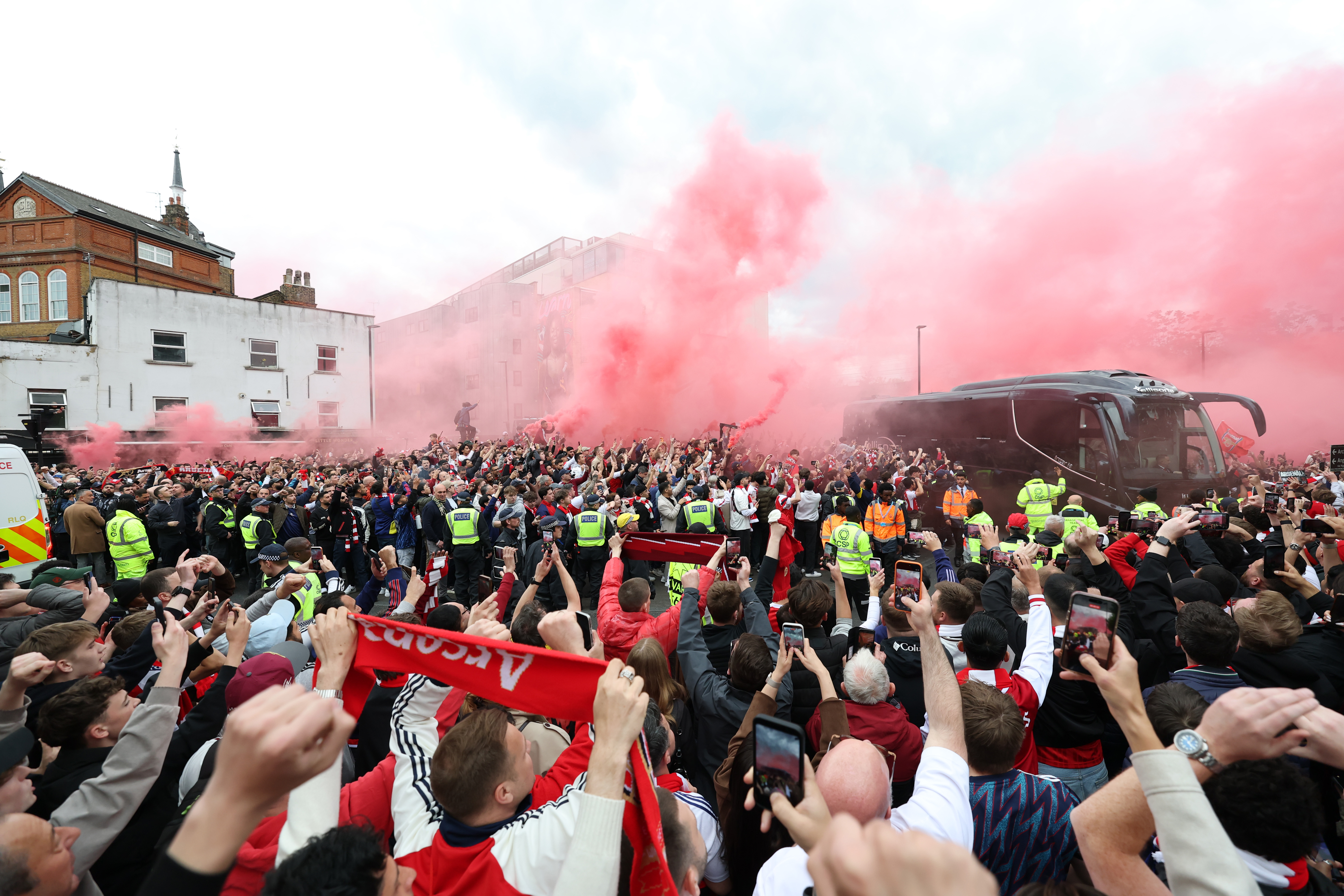LONDON, ENGLAND - MAY 05: The Arsenal team bus arrives to fans waiting outside the stadium as red smoke flares are set off prior to the UEFA Champions League 2025/26 Semi Final Second Leg match between Arsenal FC and Atletico de Madrid at Arsenal Stadium on May 05, 2026 in London, England. (Photo by Justin Setterfield/Getty Images)