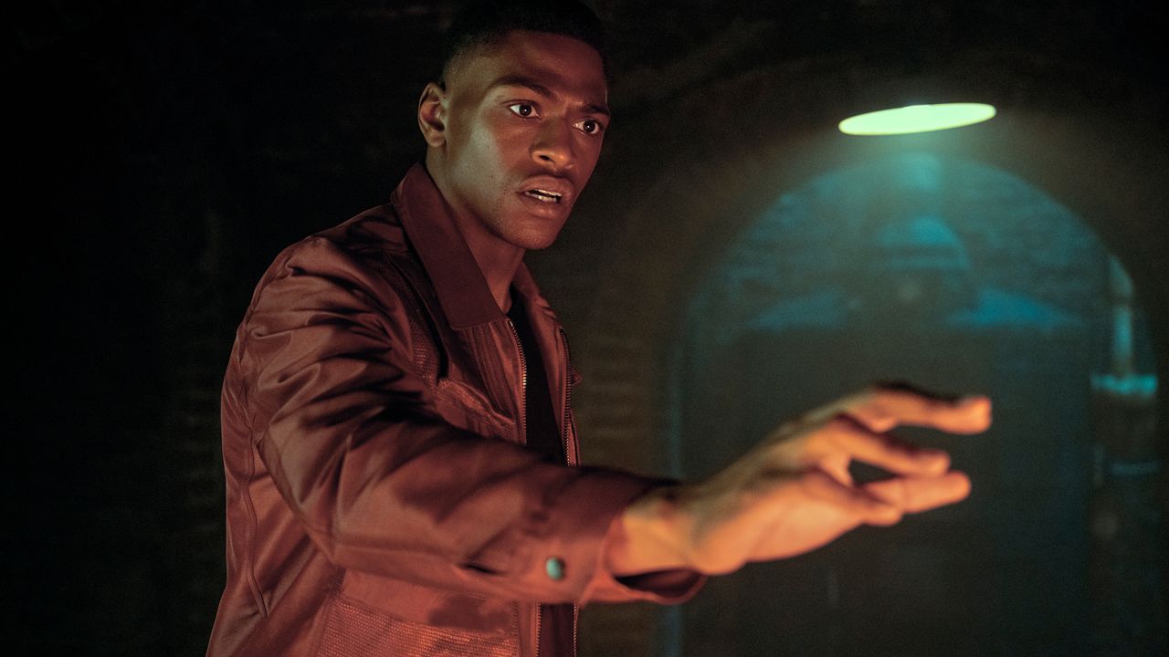 Marcus Hargreeves holds out his hand as he approaches a shiny object off screen in The Umbrella Academy season 3