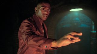 Marcus Hargreeves extiende la mano mientras se acerca a un objeto brillante fuera cámara en la tercera temporada de The Umbrella Academy