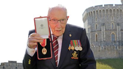 Captain Sir Thomas Moore poses after being awarded with the insignia of Knight Bachelor by Queen Elizabeth II at Windsor Castle