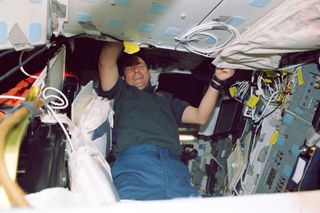 Ilan Ramon smiles for the camera while at work on the flight deck.