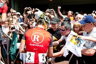 Lance Armstrong signs autographs before the start.