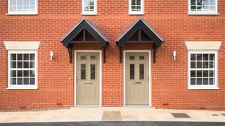 Two semi detached red brick houses with beige doors