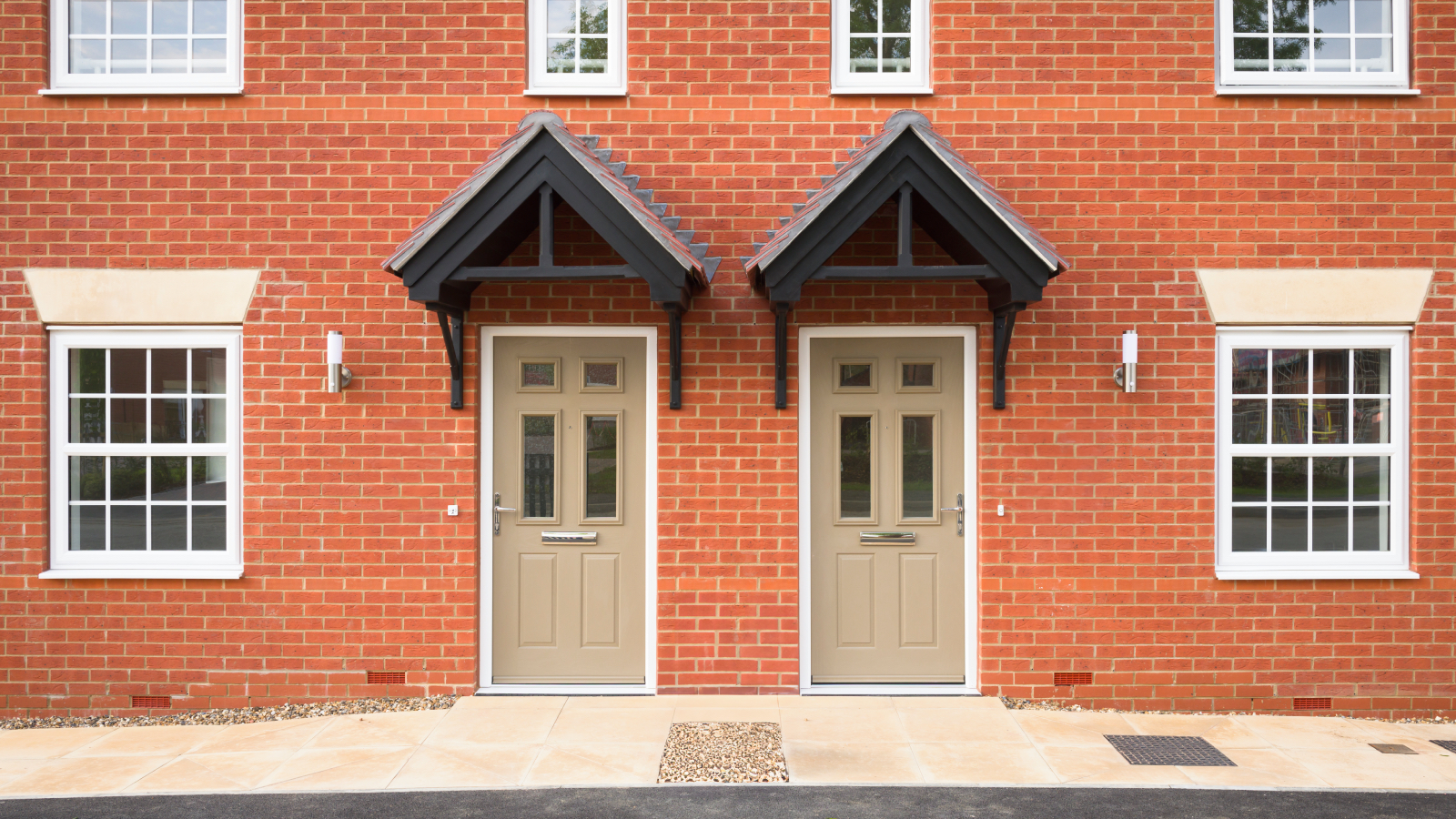 Two semi detached red brick houses with beige doors