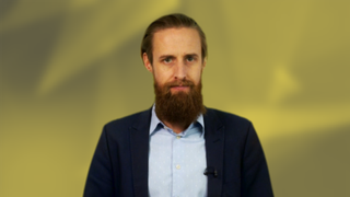 Ant Joblin, presenter of IT Pro News in Review, in front of a yellow background