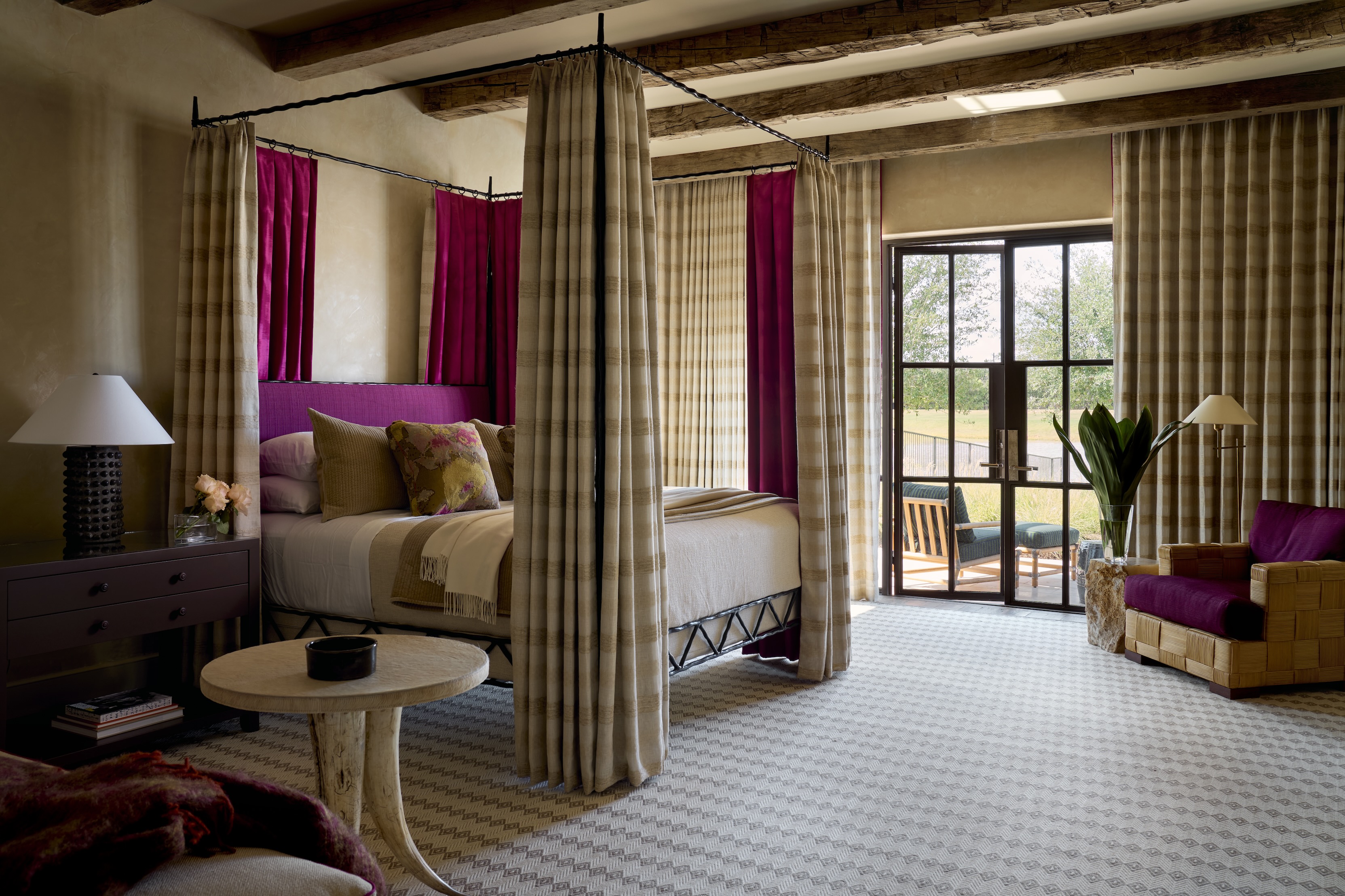 A bedroom with curtains surrounding the four-poster bed, matching the curtains on the windows.