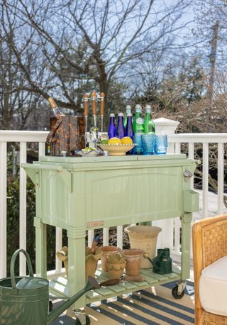 A garden bar with many accessories including an ice bucket, drinks and tools