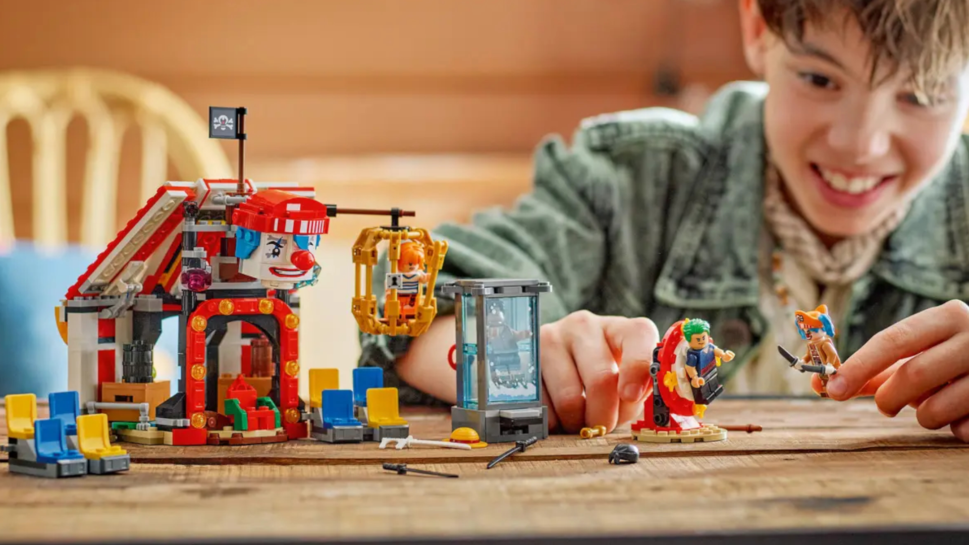 Lego Buggy the Clown's Circus Tent set on a wooden table being played with by a smiling child