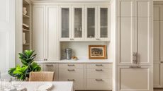 A creamy bespoke kitchen with fluted glass cabinetry and open shelving