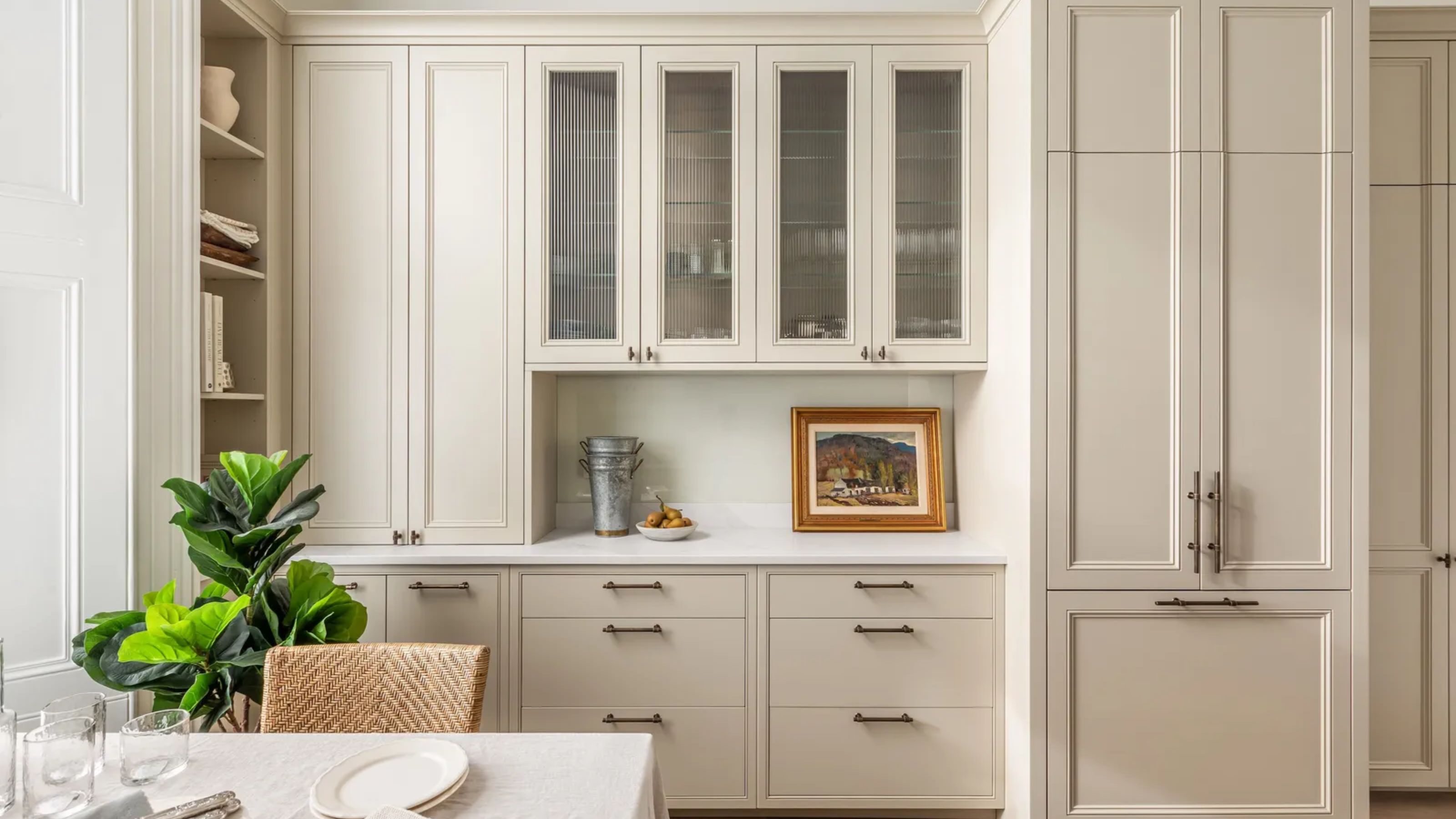 A creamy bespoke kitchen with fluted glass cabinetry and open shelving