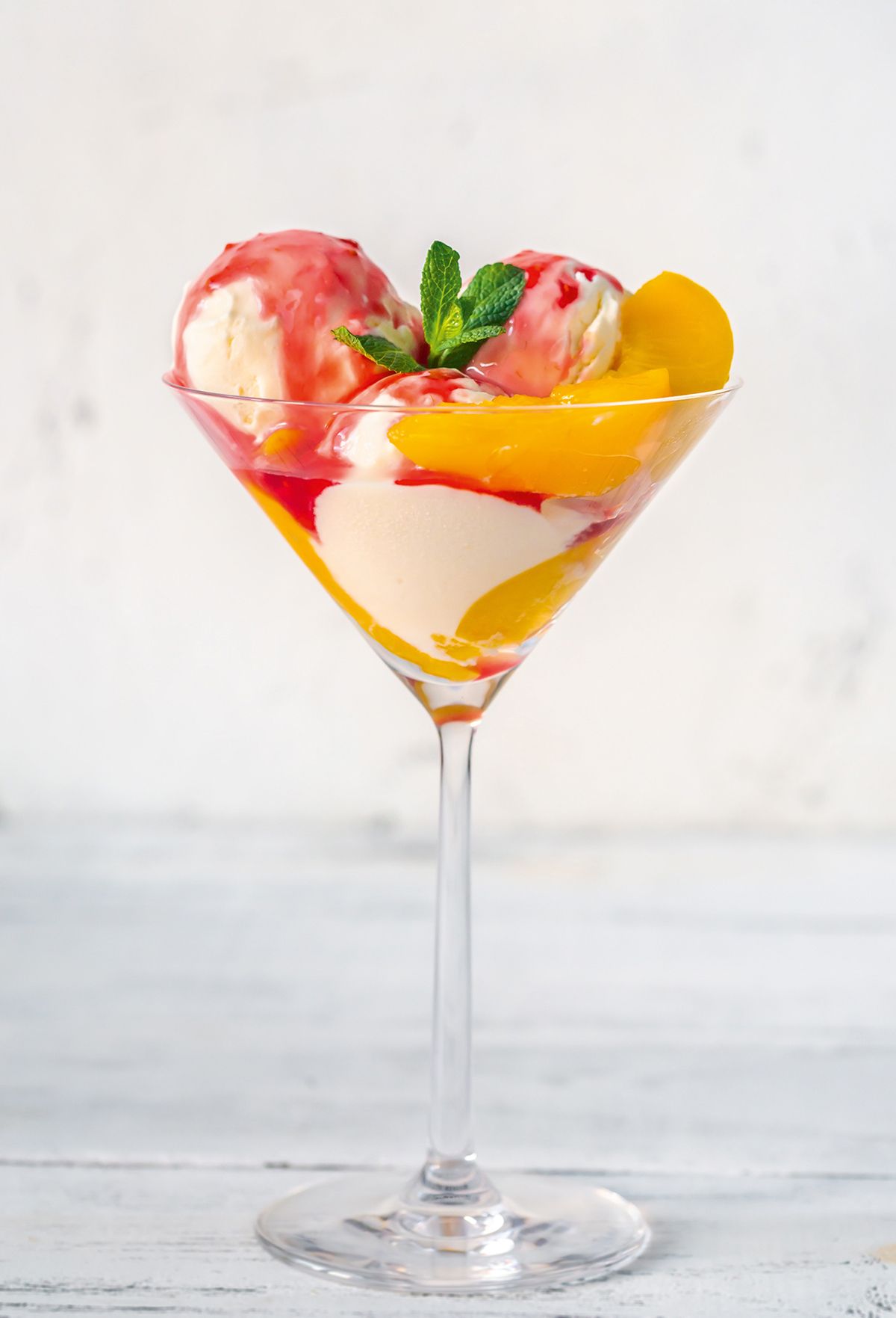 Peach Melba, the classic dessert of peaches and raspberry sauce with vanilla ice cream.