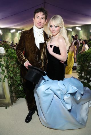 Sabrina Carpenter wearing a black gown with a puffy blue bottom standing next to Barry Keoghan at the 2024 Met Gala