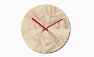 Round wooden clock with red hands