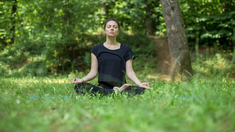 Woman outdoors doing yogic breathing exercise