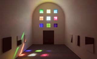 The interior of Ellsworth Kelly’s Austin chapel with coloured glass windows casting light onto his black and white marble panels