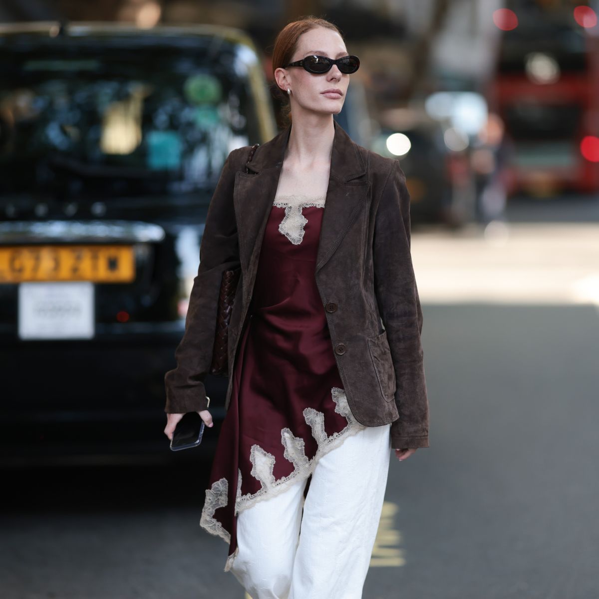 street style shot of woman wearing silk and lace top with a suede blazer