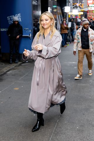 A photo of Kate Hudson arriving at Good Morning America wrapped in a taupe Giorgio Armani satin trench coat.