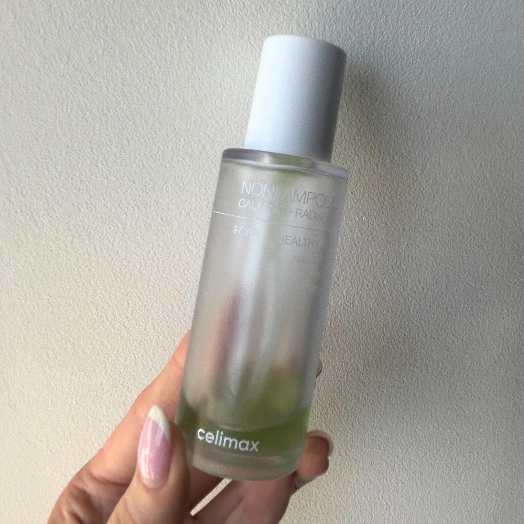 Hand holding empty bottle of Celimax Noni Energy Ampoule Serum