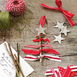 red and white ribbon around a twig in the shape of a Christmas tree with a handwritten note