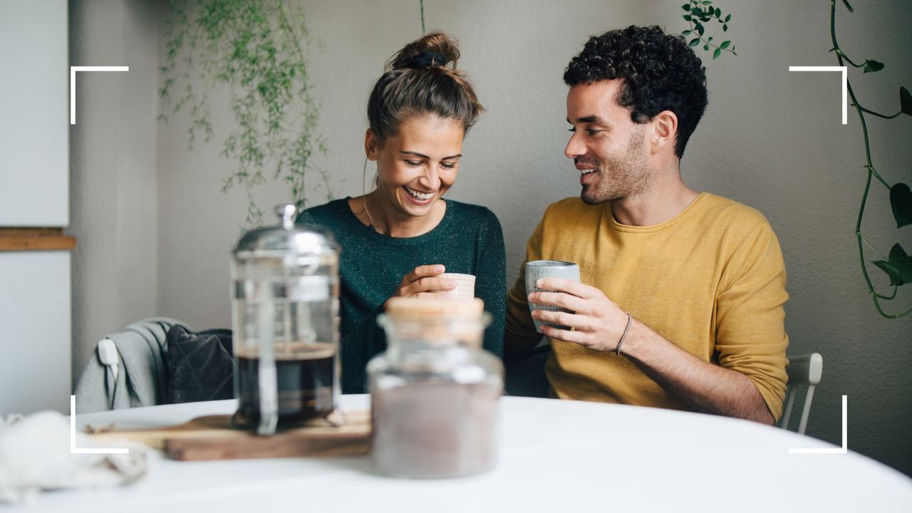 Woman and man sat at dining table with cup of coffee and filter, talking, representing how to establish deal breakers in a relationship