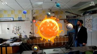 Ray Finney points to planets in virtual reality solar system