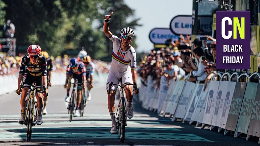 Tadej Pogačar crossing the line celebrating with the Cyclingnews Black Friday logo