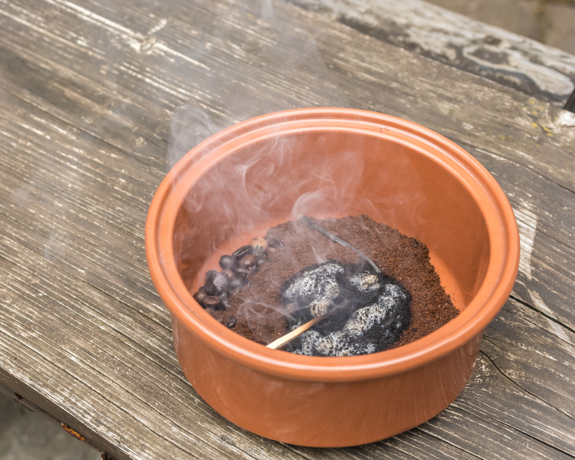 Smoldering coffee grounds in a small bowl