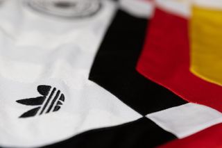 A close-up of West Germany's 1990 World Cup home shirt, featuring the Adidas trefoil logo