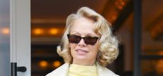 Pamela Anderson wearing tortoiseshell sunglasses and a butter yellow outfit