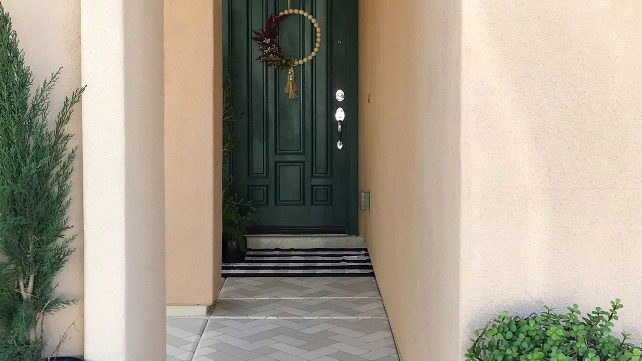 Green door with painted brick path