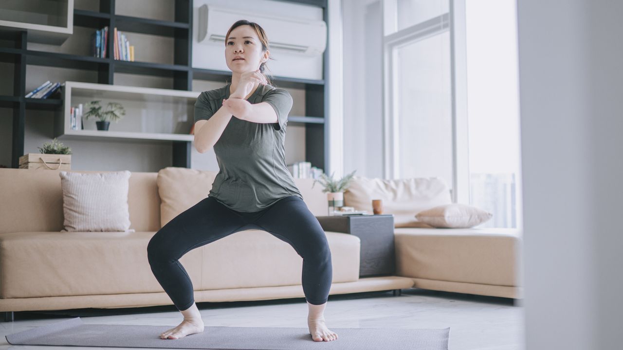 Best exercises for glutes: Image shows woman doing squats at home