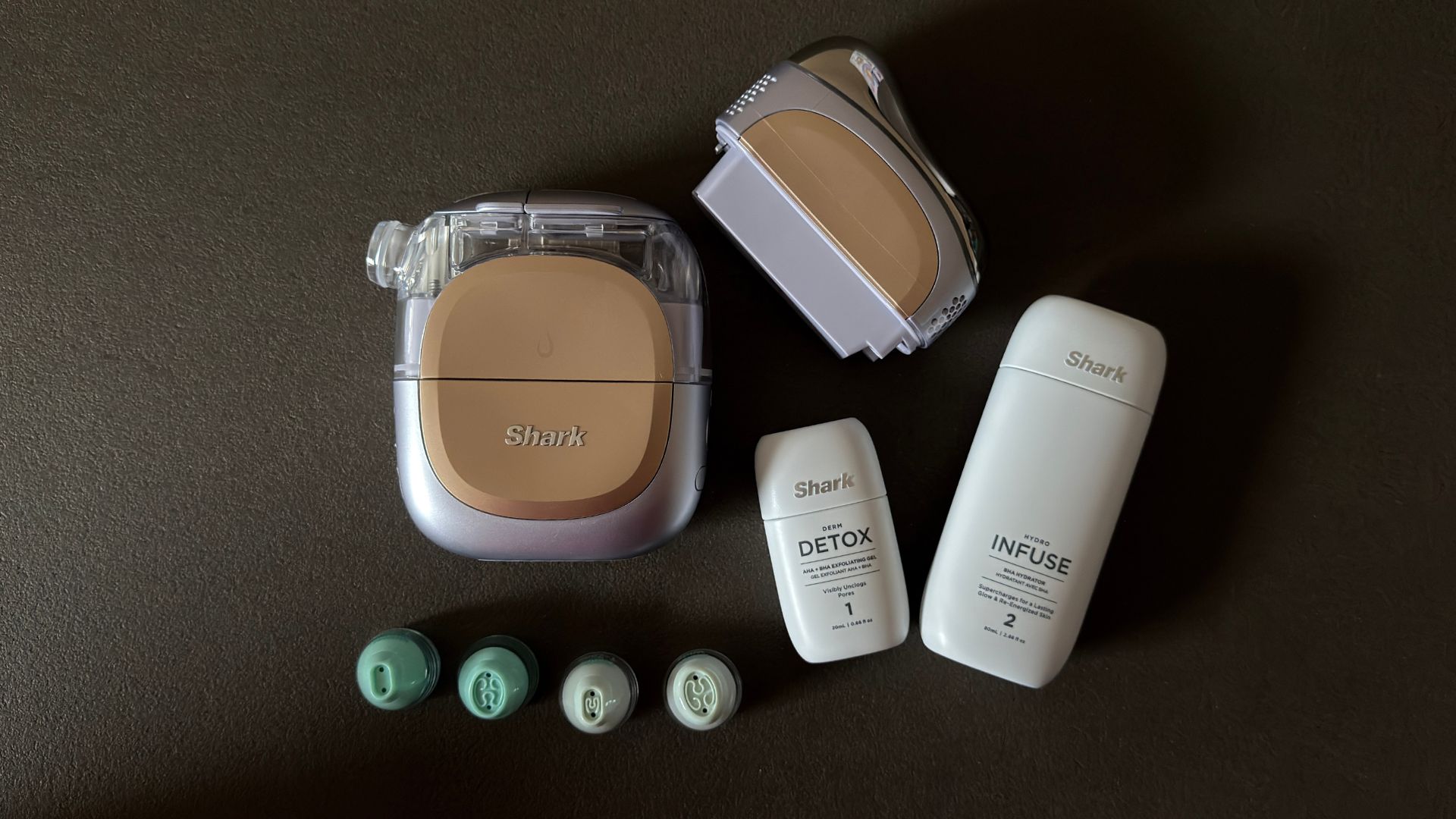 A bird&#039;s eye view of the Shark FacialPro Glow + Depuffi tool with its attachments