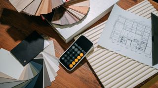 table with colour samples, design drawings and calculator