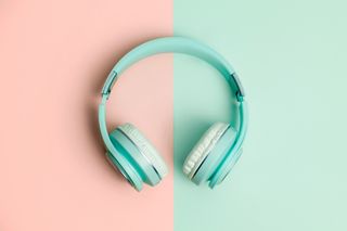Directly above view of green headphones on a salmon and green background