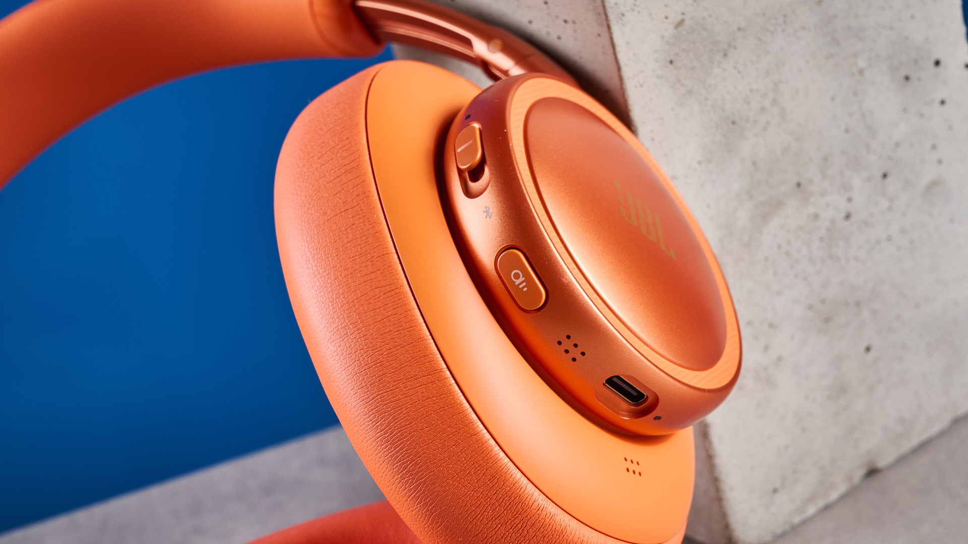 the jbl live 780NC in orange photographed against the blue tom's guide background