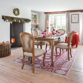 Cottage dining room with red and white Christmas decorations and log burner