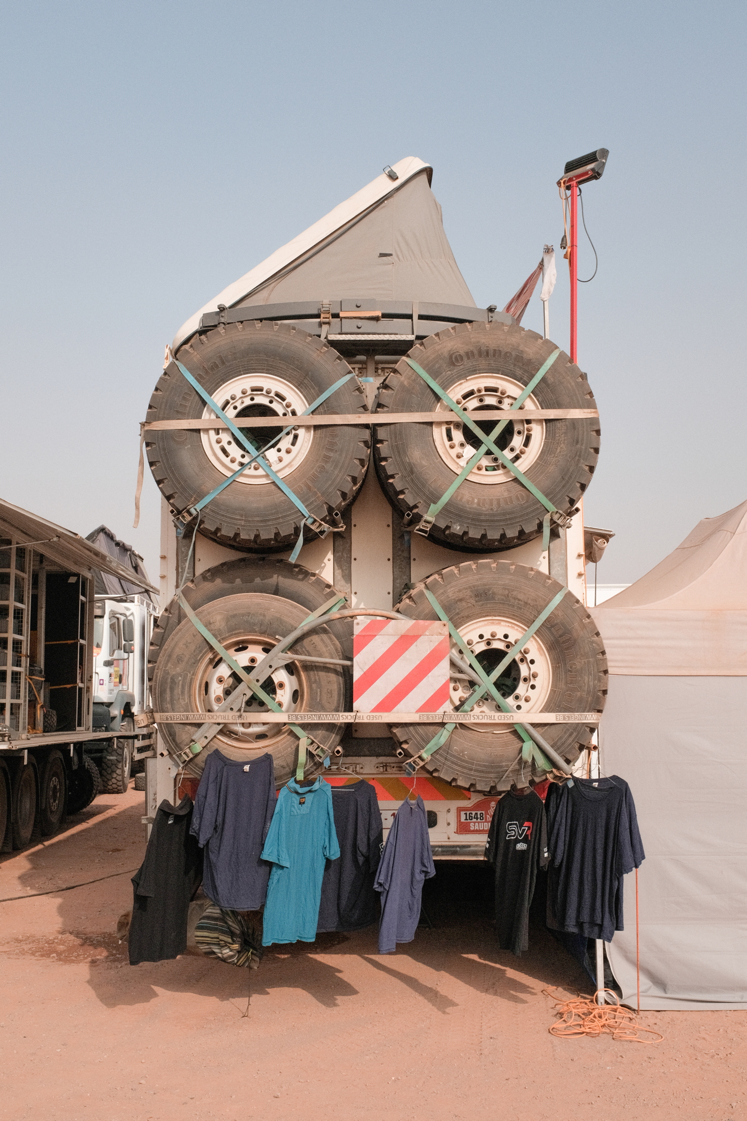 the rear of a lorry in the bivouac, showing laundry hanging up to dry on spare wheels