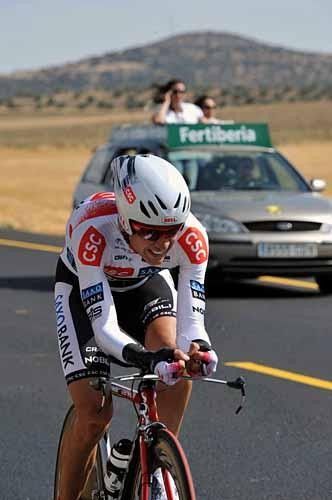 Carlos Sastre (Team CSC-Saxo Bank) is watched by some VIPs in the car behind.