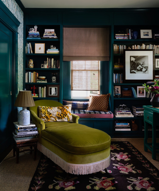 A dark blue room with an armchair and bookshelves.
